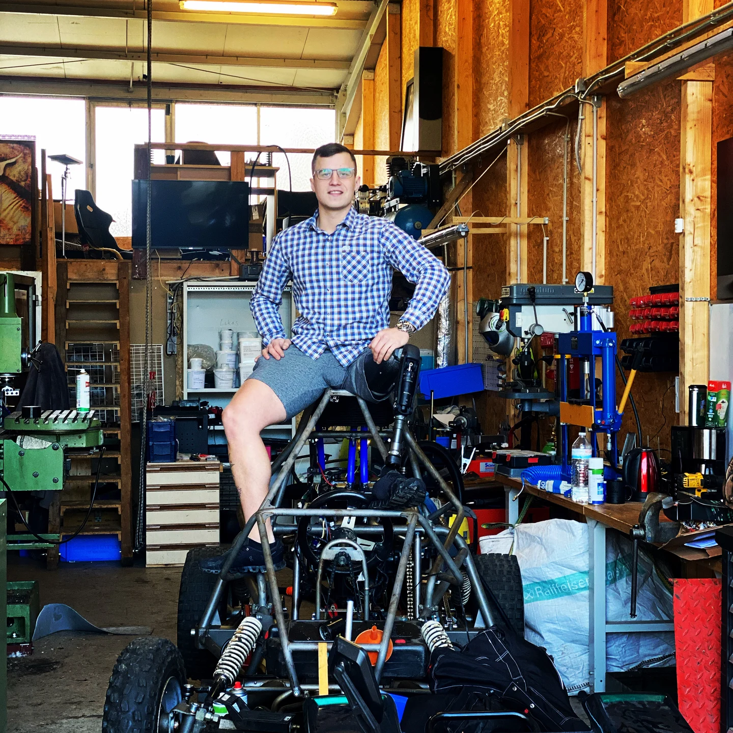Person am Rohrrahmen des Offroad-Buggys in der Werkstatt.