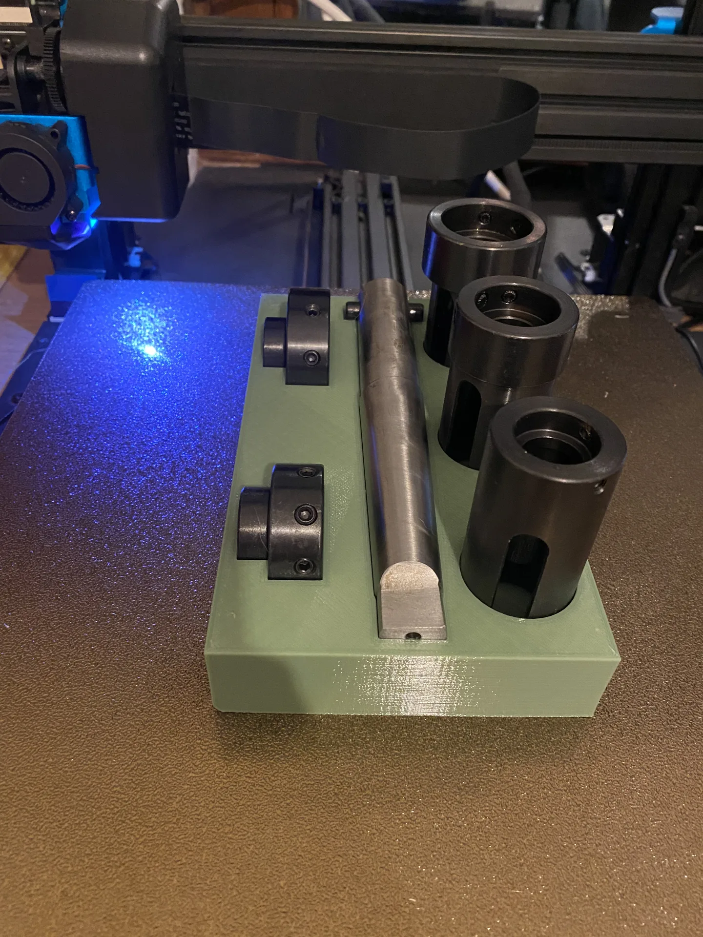 Grüner 3D-gedruckter Halter mit Teilen der Gewindeschneidvorrichtung.