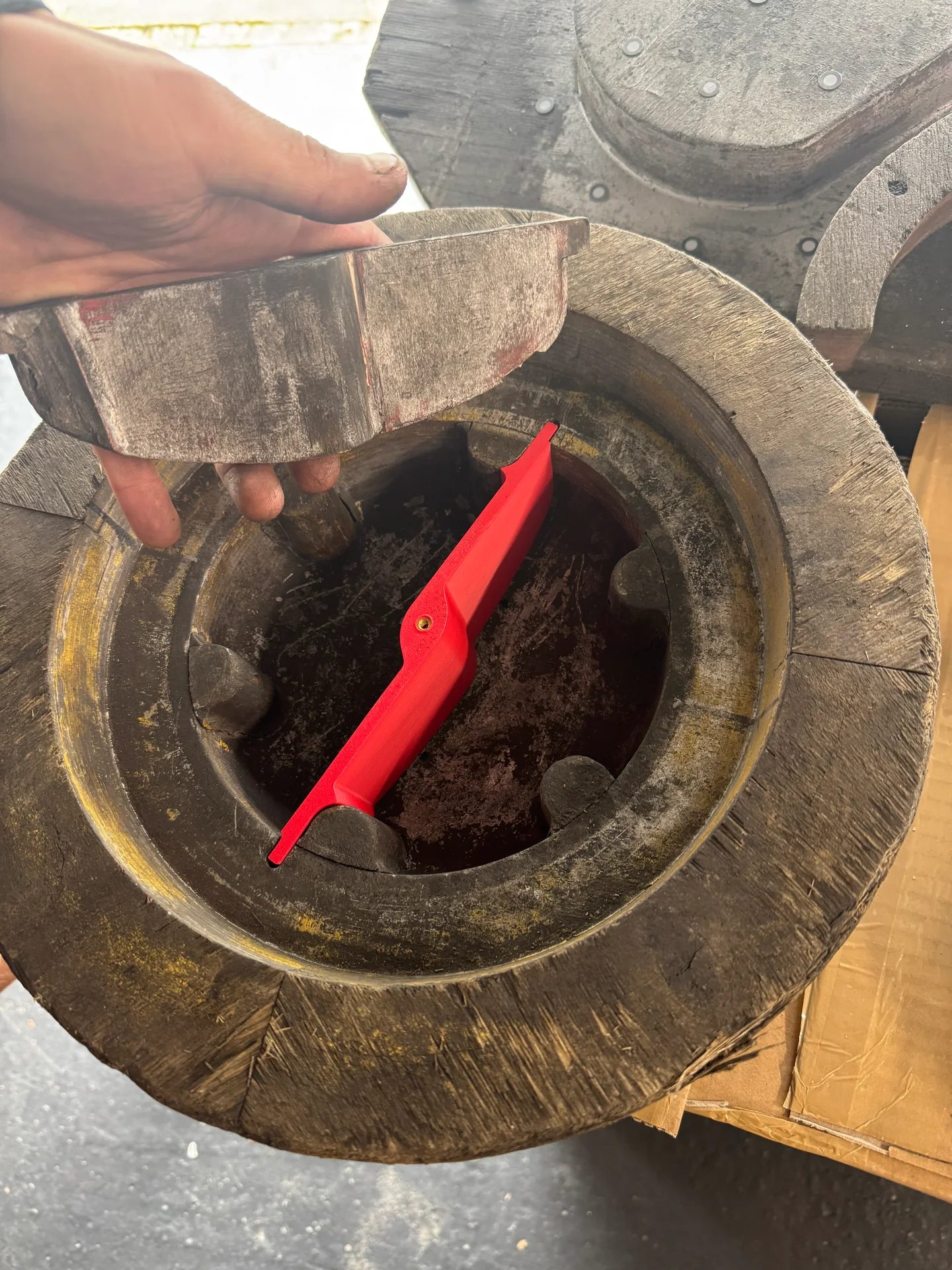 Holzoriginal und rotes 3D-Druckteil im direkten Vergleich.