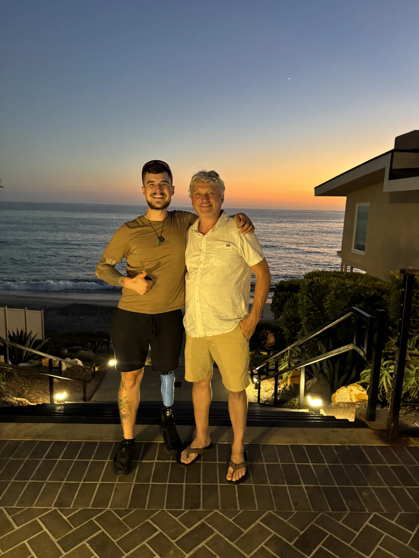 Lukas Heizmann und Alex Striler am Meer bei Sonnenuntergang.